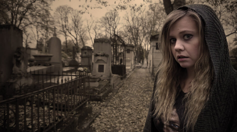 One of the best ghost hunters on youtube Amy's Crypt in a hoodie, standing in a cemetery.