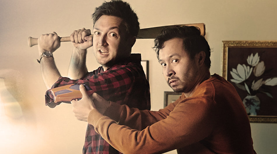 Two of the best ghost hunters on youtube Shane and Ryan from Buzzfeed Unsolved Network, holding a baseball bat with angry faces in a lounge room.