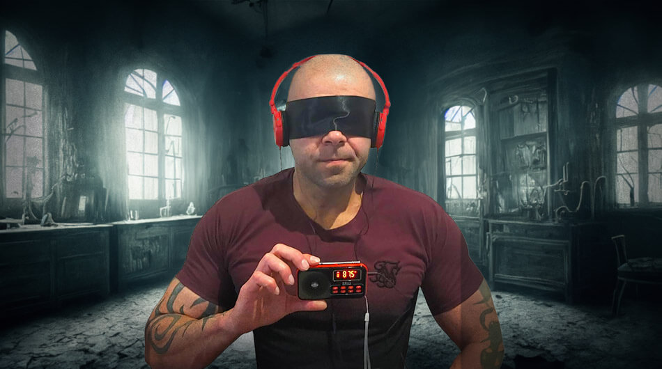 Man using a 'ghost box' also know as a 'spirit box'. He has head phones and a blind fold on sitting in a creepy looking room.